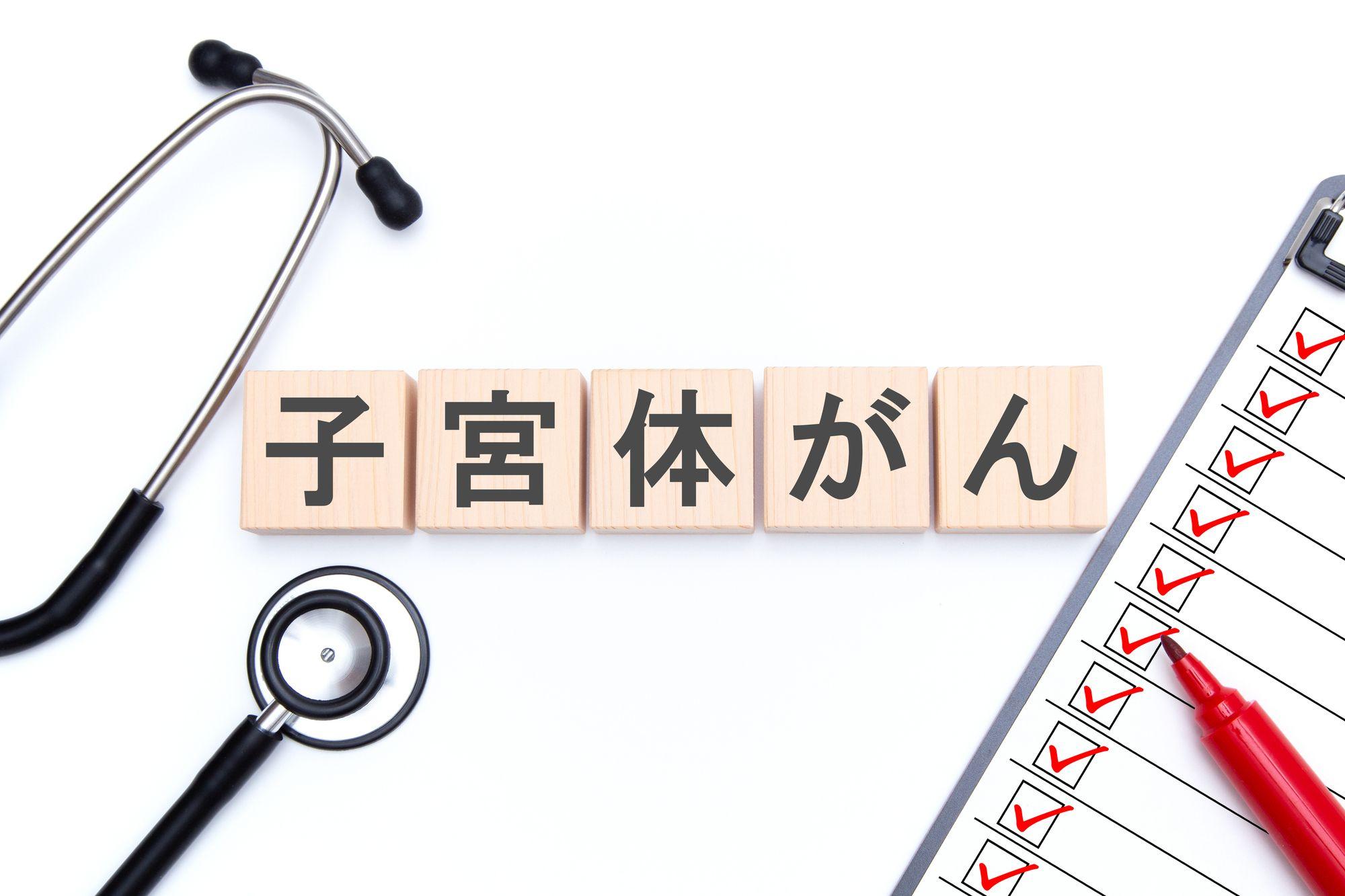 子宮体がんと書かれたプレートと聴診器、問診票